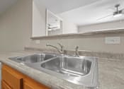 Thumbnail 13 of 39 - a kitchen with a stainless steel sink and a mirror