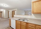 Thumbnail 26 of 66 - A kitchen with wooden cabinets and a white dishwasher.