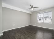 Thumbnail 14 of 22 - an empty living room with a ceiling fan and a window