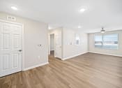 Thumbnail 16 of 35 - an empty living room with white walls and wood floors