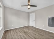 Thumbnail 25 of 51 - an empty living room with a ceiling fan and a door