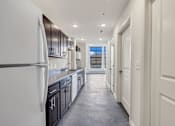 Thumbnail 26 of 51 - a kitchen with black cabinets and white appliances