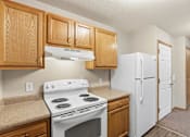 Thumbnail 27 of 66 - A kitchen with a white stove and refrigerator.