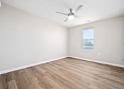Thumbnail 17 of 35 - an empty living room with a ceiling fan and a window