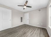 Thumbnail 17 of 51 - an empty living room with a ceiling fan and white doors