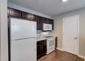 Thumbnail 10 of 32 - a kitchen with dark wood cabinets and white appliances