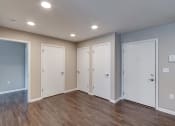 Thumbnail 22 of 32 - a bedroom with two doors and a hardwood floor