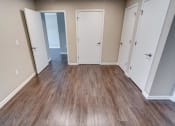 Thumbnail 20 of 32 - a bedroom with a hardwood floor and several doors