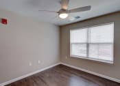Thumbnail 29 of 32 - an empty bedroom with a ceiling fan and a large window