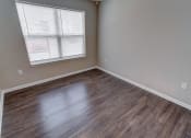 Thumbnail 21 of 32 - a bedroom with hardwood floors and a window