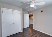 Thumbnail 17 of 32 - a bedroom with a ceiling fan and a door to a bathroom