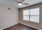 Thumbnail 26 of 32 - a bedroom with a large window and a ceiling fan