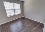 Thumbnail 14 of 32 - a bedroom with hardwood floors and a large window