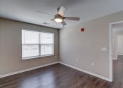 Thumbnail 24 of 32 - a bedroom with hardwood floors and a ceiling fan