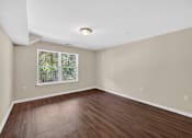 Thumbnail 29 of 51 - Empty room with wooden floor and a window.