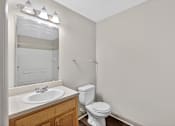 Thumbnail 34 of 51 - A white toilet sits next to a sink in a small bathroom.