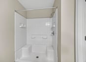 Thumbnail 33 of 51 - A white bathroom with a shower stall and a toilet.