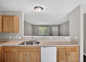 Thumbnail 21 of 51 - A kitchen with wooden cabinets and a white dishwasher.