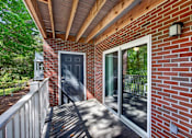 Thumbnail 37 of 51 - A red brick house with a black door and a glass window.