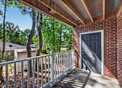Thumbnail 36 of 51 - A wooden deck with a metal railing and a grey door.