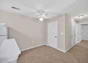 Thumbnail 24 of 48 - A room with a white ceiling fan and carpeted floor.