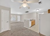 Thumbnail 20 of 48 - A spacious room with a ceiling fan and a kitchenette.