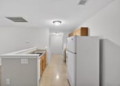 Thumbnail 22 of 48 - A kitchen with a refrigerator, sink, and cabinets.
