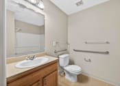 Thumbnail 32 of 48 - A white toilet sits next to a white sink in a bathroom.