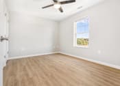 Thumbnail 13 of 26 - an empty living room with a ceiling fan and a window