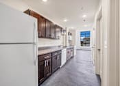 Thumbnail 24 of 51 - a kitchen with white appliances and wooden cabinets