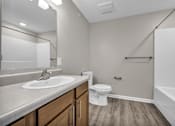 Thumbnail 5 of 18 - A bathroom with a white sink, toilet, and bathtub.