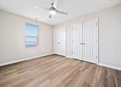 Thumbnail 18 of 35 - an empty living room with two doors and a ceiling fan