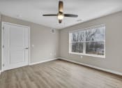 Thumbnail 38 of 51 - an empty living room with a large window and a ceiling fan