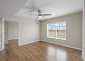 Thumbnail 17 of 39 - an empty living room with a ceiling fan and a window