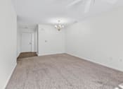 Thumbnail 30 of 49 - A room with a carpeted floor and a ceiling fan.