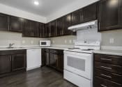 Thumbnail 17 of 22 - a kitchen with white appliances and dark wood cabinets