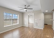 Thumbnail 24 of 39 - an empty living room with a ceiling fan and a window