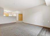 Thumbnail 30 of 66 - A large empty room with a carpeted floor and a door at the end.