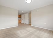 Thumbnail 21 of 76 - an empty living room and kitchen with wood flooring and white walls