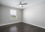 Thumbnail 12 of 22 - an empty living room with a ceiling fan and a window