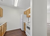 Thumbnail 26 of 49 - A kitchen with a white refrigerator, white oven, and wooden cabinets.