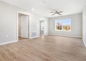 Thumbnail 17 of 26 - an empty living room with a ceiling fan and a window