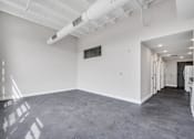 Thumbnail 35 of 51 - a large room with white walls and a concrete floor