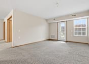 Thumbnail 32 of 66 - A large, empty room with a carpeted floor and a window with blinds.