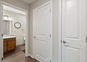 Thumbnail 26 of 37 - a bathroom with white doors and a sink and a mirror
