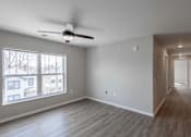 Thumbnail 3 of 58 - A spacious room with a ceiling fan and a long hallway.