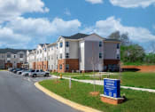 Thumbnail 1 of 22 - an apartment building with cars parked in front of it