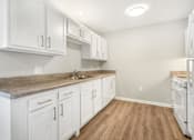 Thumbnail 18 of 26 - a white kitchen with white cabinets and white appliances
