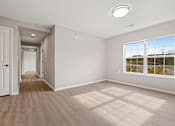 Thumbnail 6 of 78 - an empty living room with a door to a hallway