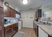 Thumbnail 33 of 50 - a kitchen with dark wood cabinets and white appliances